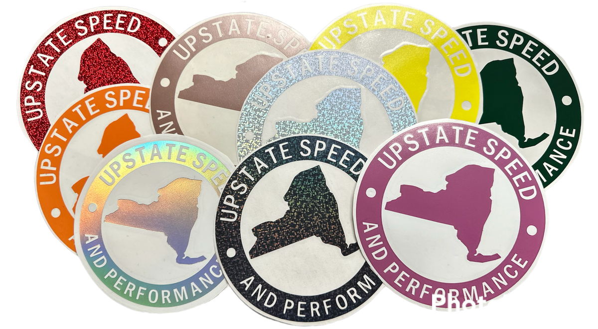Various colors of round, vinyl, 6 inch Upstate Speed logo stickers.