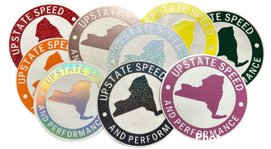 Various colors of round, vinyl, 6 inch Upstate Speed logo stickers.